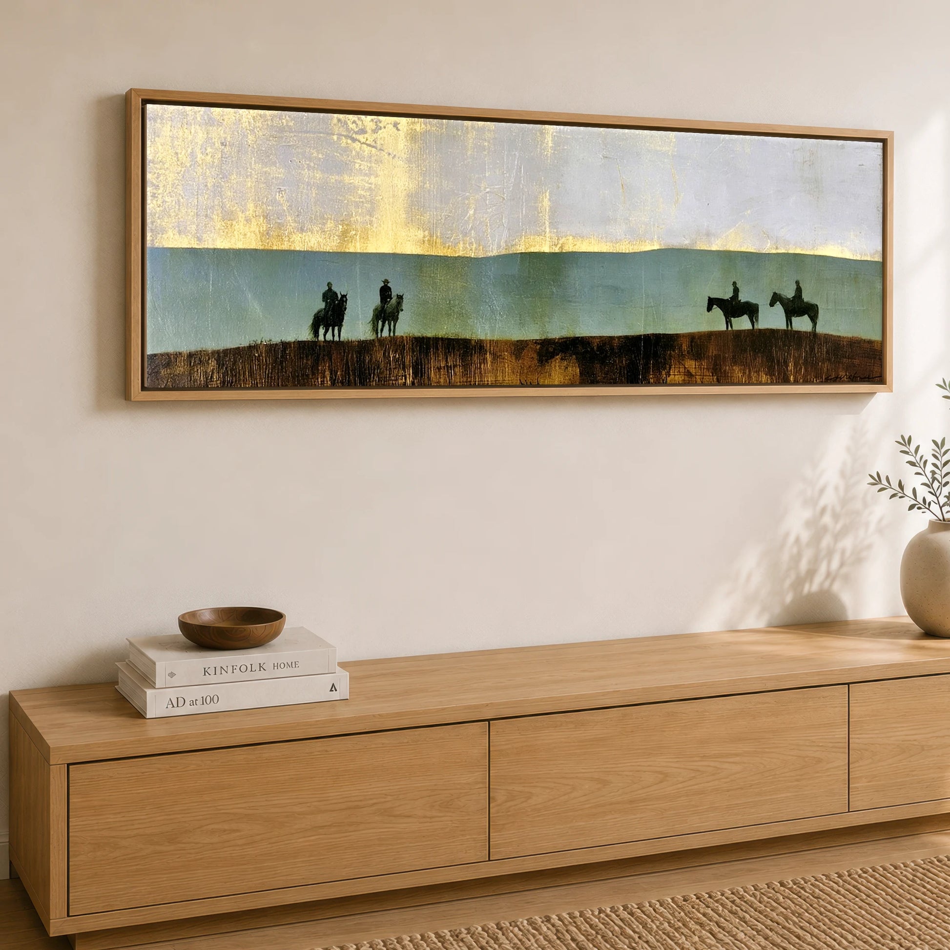 The Gilded Ridge Horse & Rider panoramic canvas wall art displayed above a sideboard
